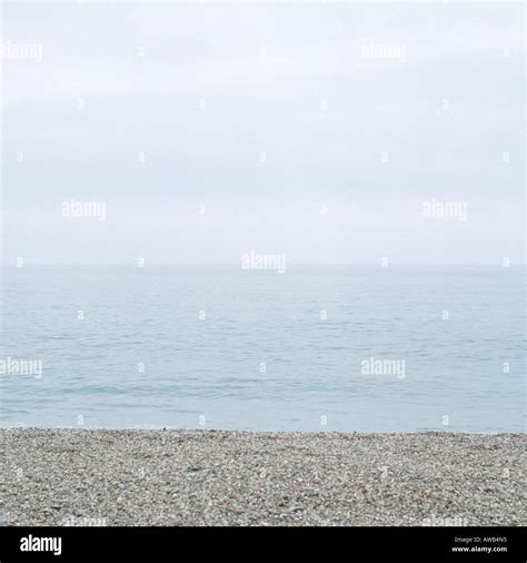 The Grey Pebblestone Beach Blue Sea And Overcast Sky Stock Photo Alamy