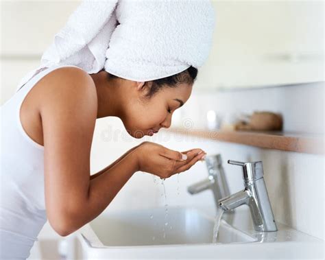 My Skin Care Routine Shot Of A Young Woman Washing Her Face At The