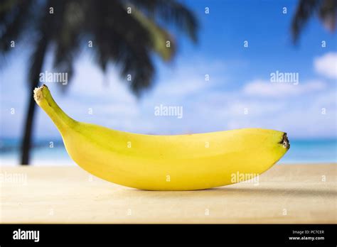 One Whole Fresh Yellow Banana With Palm Trees On The Beach In