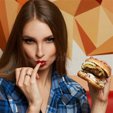 Beautiful Woman Holding Burger And Licking Her Finger Stock Image