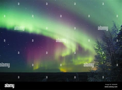 Colorful Northern Lights Aurora Borealis With Red Oxygen Glow Above A