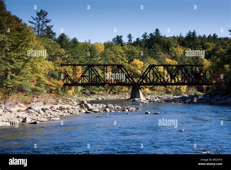 An Old Railroad Bridge With A Backdrop Of Fall Foliage Crosses The