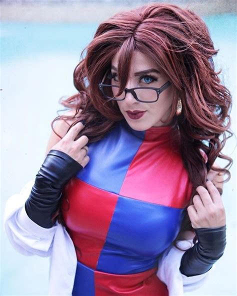 A Woman Wearing Glasses And A Red Blue And Black Costume Is Posing For