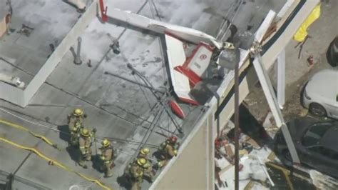 One Dead One Injured After Small Plane Crashes Onto Strip Mall Roof In