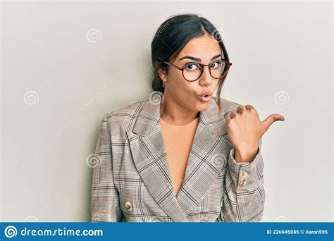 Young Brunette Woman Wearing Business Jacket And Glasses Surprised