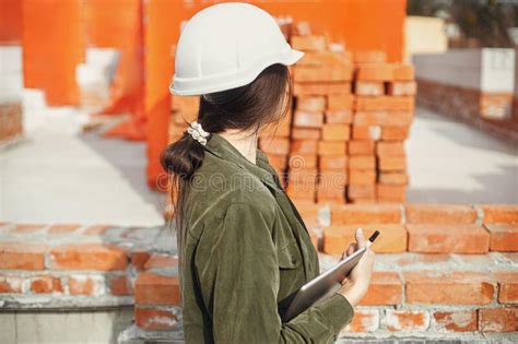 Stylish Woman Architect With Tablet Blueprints At Construction Site