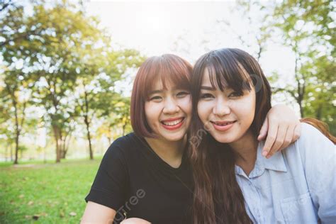 background dua teman wanita muda asia yang cantik dan bahagia bersenang senang bersama di taman