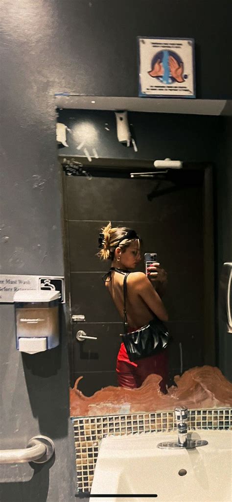 A Woman Taking A Selfie In The Bathroom Mirror
