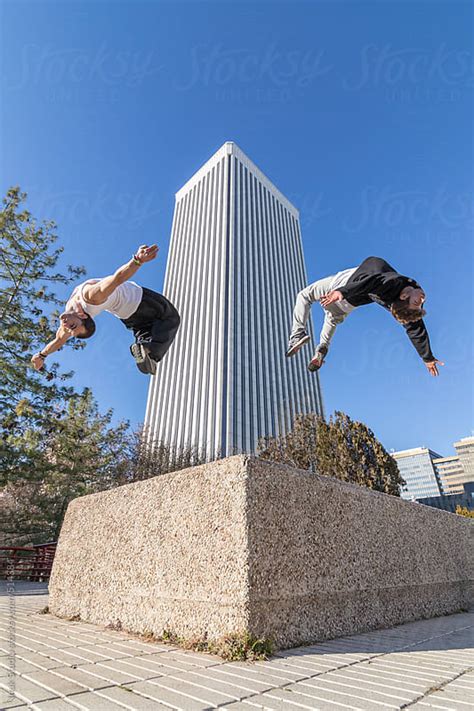 Two Men Doing A Backflip In The Air With A Building Background By Inuk