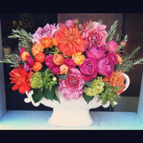 A White Vase Filled With Lots Of Colorful Flowers