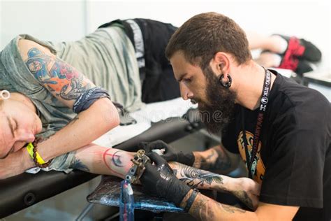 Professional Artist Doing Tattoo On Client Arm Editorial Stock Photo