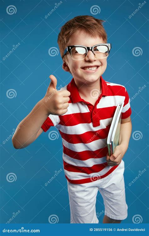 Nerdy Kid In Retro Eyeglasses And Red Striped Shirt Holding Textbooks