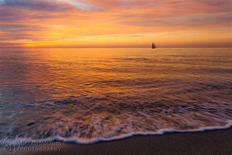 A Pastel Sunset And A Sailboat Off Of A Florida Beach Landscape
