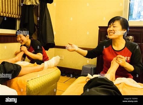 Chengdu Sichuan Province China Two Masseuses Apply A Chinese Foot Massage To Clients At A