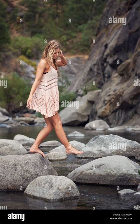 Une jeune femme aux pieds nus dans une robe d été de marcher à travers