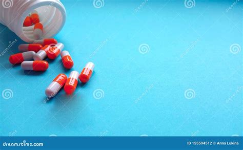 Red And White Antibiotic Capsule Pills Spread Out Of White Plastic Drug