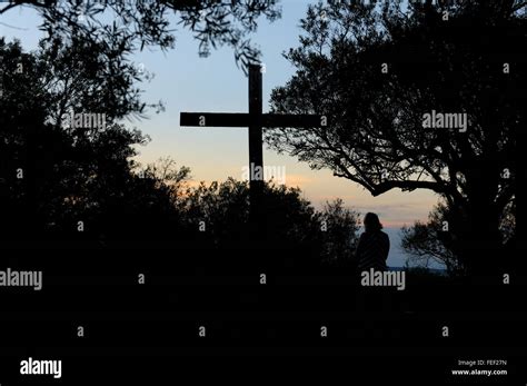 Person Kneeling In Front Of Cross Stock Photo Alamy