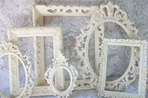 Three White Frames Sitting Next To Each Other On A Lace Covered
