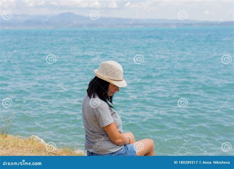 Beautiful Lifestyle Woman Sitting And Relaxing On The Shore Of Lake Contemplating Amazing