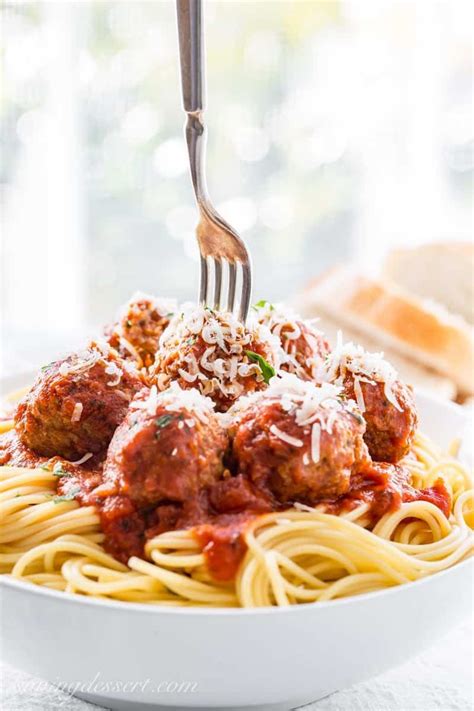 These homemade meatballs are juicy, soft, and full of flavor. Bowl of spaghetti with meatballs and shredded Parmesan ...