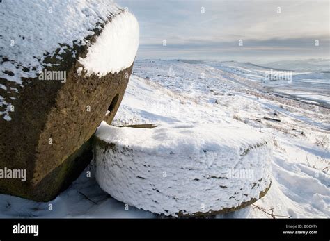 Two Millstones In Winter Snow Under Stanage Edge In The Peak