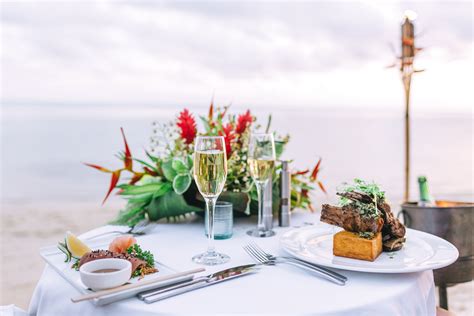 private dining on the beach with little polynesian toes in white sand the sunset glow