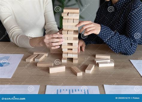 Close Up Diverse Colleagues Building Tower From Wooden Blocks Stock