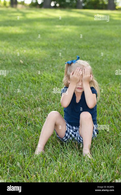 Kleines Mädchen sitzen auf der Wiese zeigt Ausdruck Stockfotografie Alamy