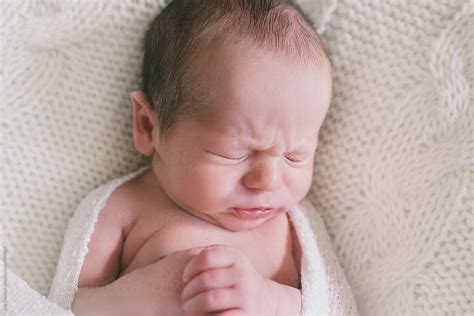 Portrait Of A Sleeping Newborn Baby With A Frown On His Face By