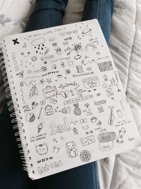 Someone Is Holding A Notebook With Doodles On It
