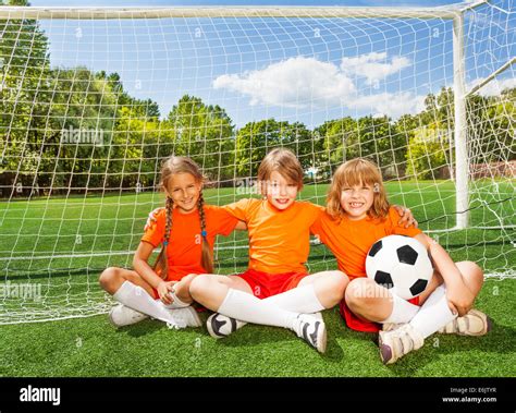 Smiling Children Sitting On Grass With Football Stock Photo Alamy