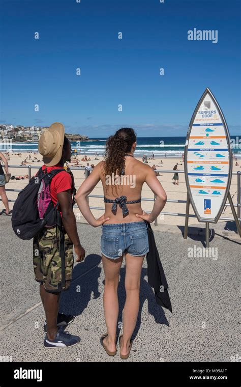 couple on promenade reading surfer s code notice bondi beach sydney new south wales