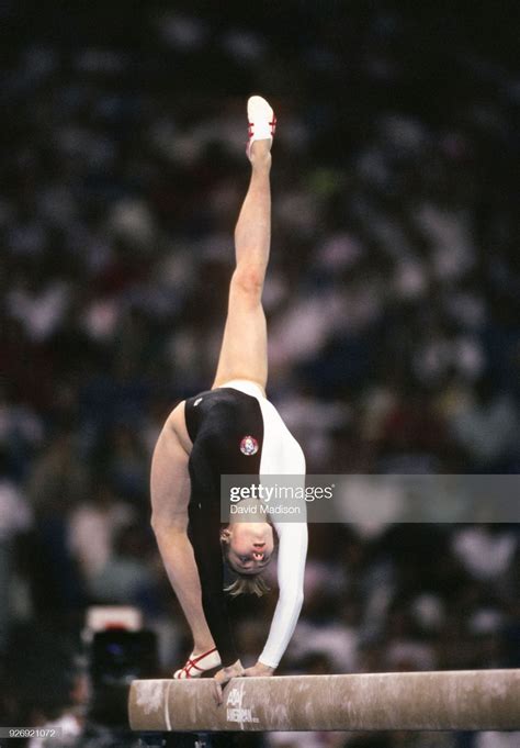 A Woman Doing Gymnastics On The Balance Beam