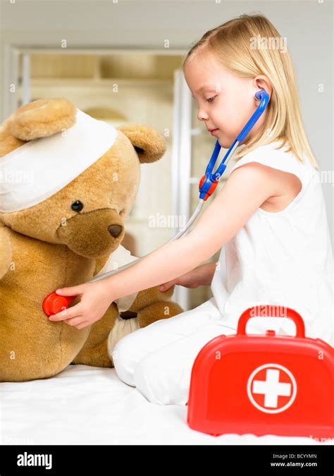 Girl Playing Doctor With Teddy Bear Stock Photo Alamy