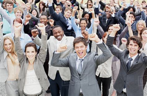 Portrait Of Business People Cheering With Arms Raised In Crowd Stock