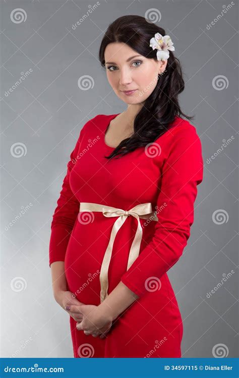 Beautiful Pregnant Woman In Red Dress Over Grey Background Stock Image
