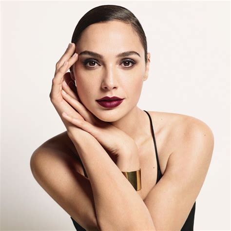 A Woman With Her Hand On Her Face And Wearing A Black Dress Posing For