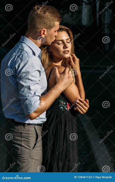 O Homem Beija Uma Menina Na Rua Abraçando A Atraída Entre Si Menina Em Um Vestido Preto