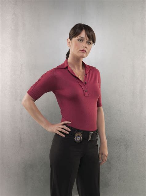 A Woman Standing With Her Hands On Her Hips Wearing A Red Shirt And Black Pants