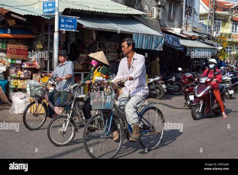 Vietnamese Male Rides Bicycle In Traffic Through Hoi An Vietnam Stock