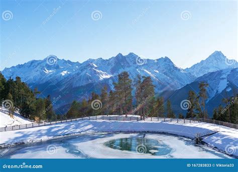 Winter Sunny Landscape With Snowy Peaks Of Mountain Ranges With Green