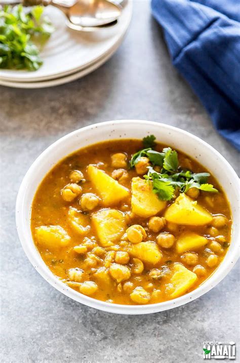 Two Hands Holding A Bowl Of Stew With Pineapples And Chickpeas In It