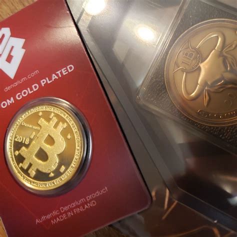 Two Gold Plated Bitcoins Sitting On Top Of Each Other In A Box