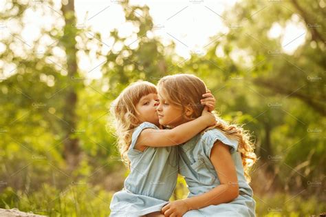 Two Cute Little Sisters Kiss High Quality People Images ~ Creative