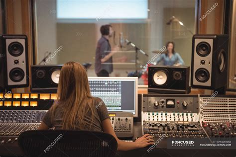 Rear View Of Audio Engineer Using Sound Mixer In Recording Studio