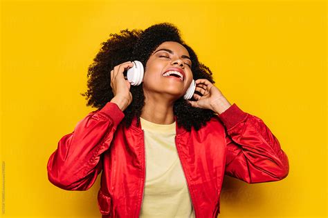 Beautiful Afro Woman Listening To Music With White Headphones By