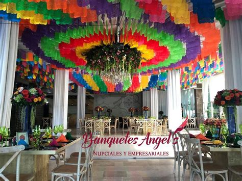 A Room Filled With Tables And Chairs Covered In Multicolored Tissue Paper Cranes Hanging From