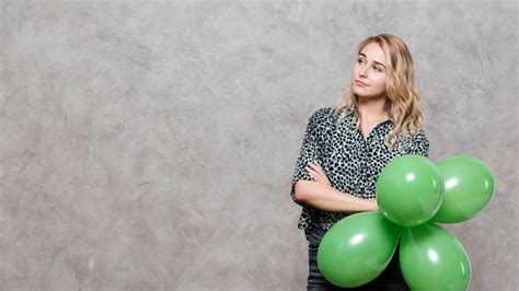 Free Photo Thinking Woman Holding A Bunch Of Balloons