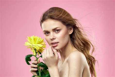 Beautiful Girl With A Yellow Flower On A Pink Background Nude Shoulders