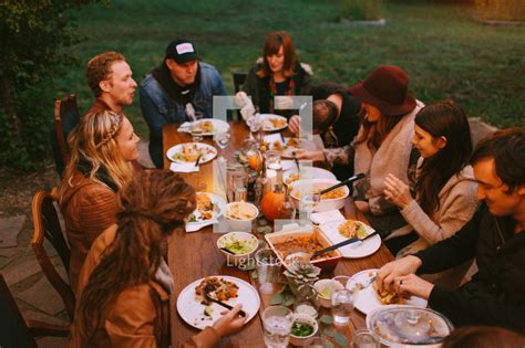At holiday time, people tend to arrive hungry (and ready to indulge), so don't make them wait too long for the main event. A fall dinner party outdoors — Photo — Lightstock